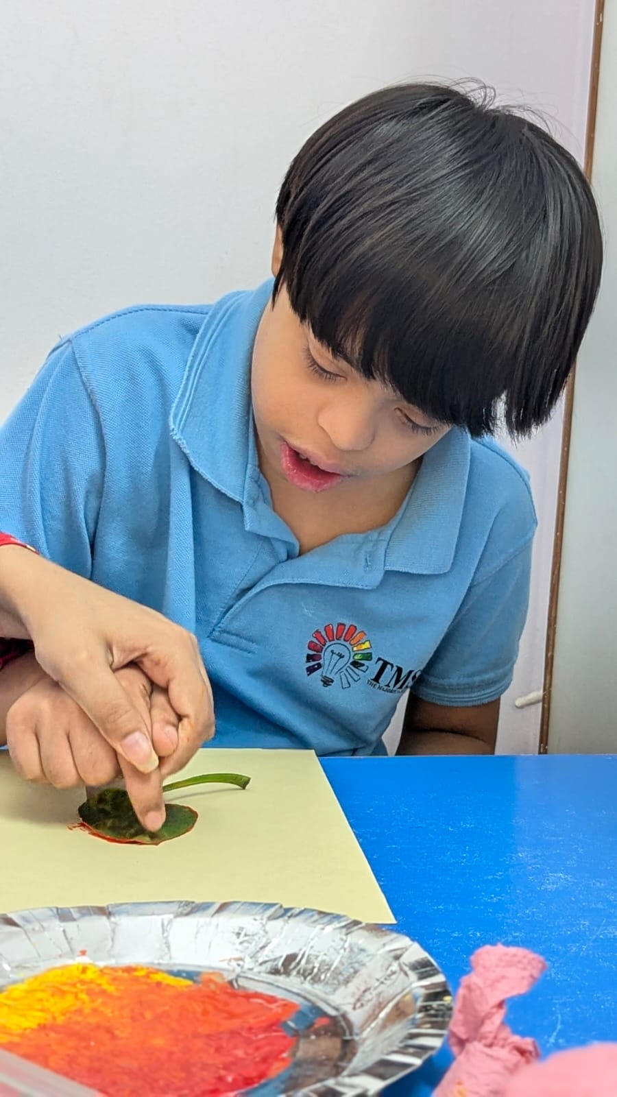 Student in TMS polo during a hands-on learning activity