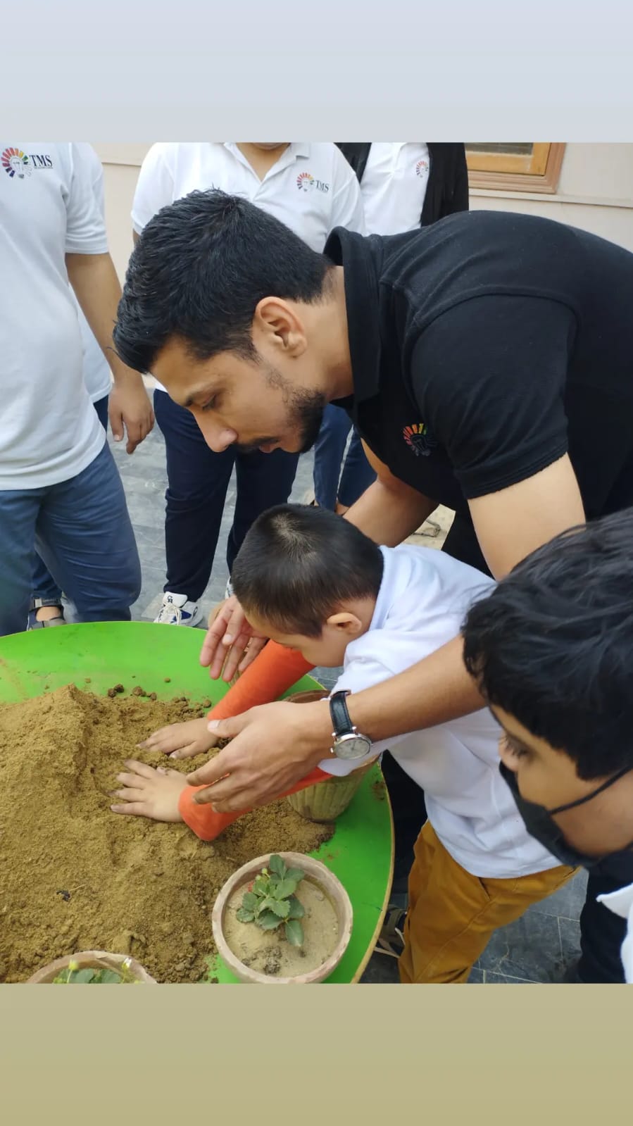 Wajih Ahmed with students during a planting activity at Majoris